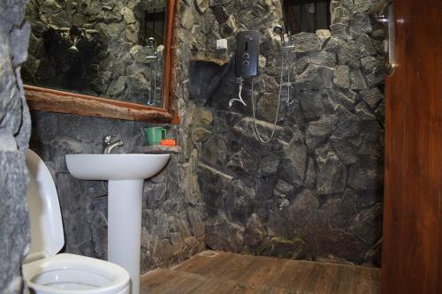 a stone bathroom with a sink and a toilet at Marian Holiday Bungalow in Puttalam