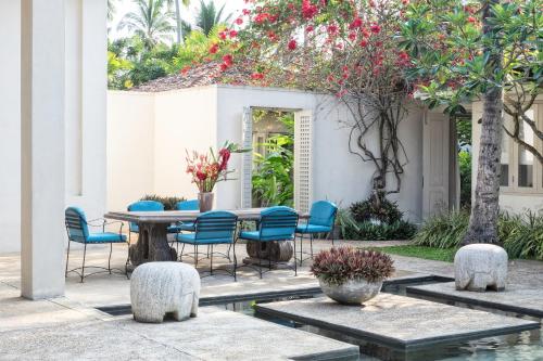 a patio with a table and chairs and flowers at Elysium in Unawatuna