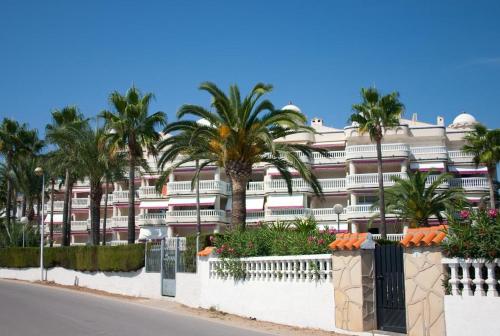 a large building with palm trees in front of a street at Apartment Martinez Casablanca in Alcossebre