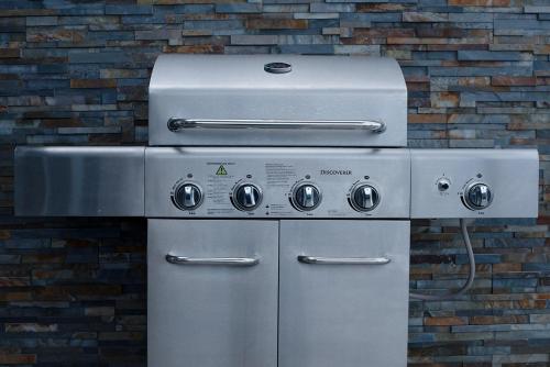a grill andrigerator in front of a brick wall at Casey's Beach Retreat in Batehaven