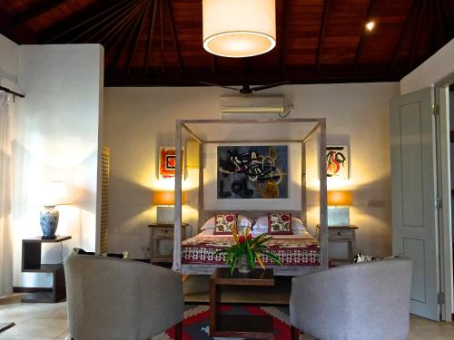 a bedroom with a bed with a table and chairs at Elysium in Unawatuna