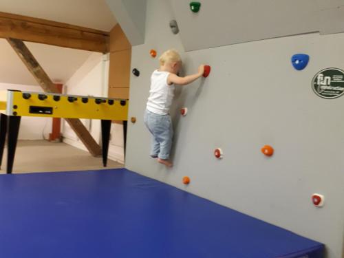 a young child playing on a climbing wall at Bodenhof Ferienwohnungen in Fieberbrunn