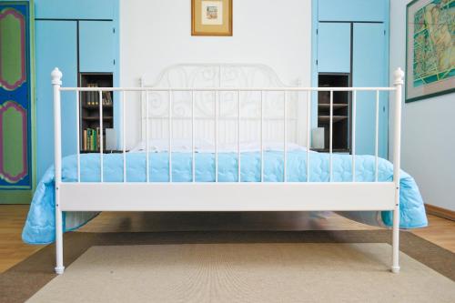 un letto bianco in una camera con pareti blu di La Casa Dell'Artista a Fermo