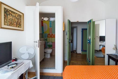 een woonkamer met een oranje bed en een badkamer bij La Casa Dell'Artista in Fermo