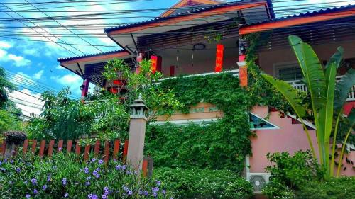 a house with ivy growing on the side of it at Lampang Lanna Home in Lampang