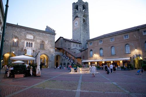 a town square with a clock tower in the distance at GombitHotel in Bergamo