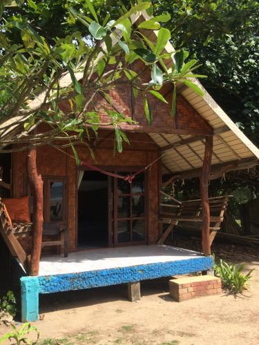 a small house with a blue bench in front of it at Sanctuary Lanta in Ko Lanta