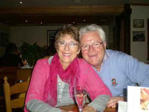 a man and woman sitting at a table with a wine glass at Alpina in Leukerbad