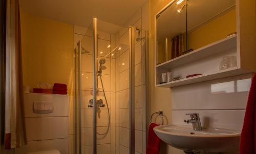 uma casa de banho com um chuveiro e um lavatório. em Hotel Zum Alten Siel em Greetsiel