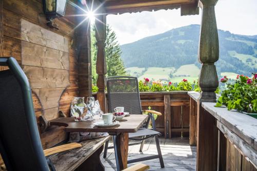a table and chairs on a porch with a view at Landhaus Alpbach in Alpbach