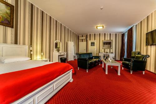 ブカレストにあるVila Siaのベッド1台と椅子2脚が備わるホテルルームです。