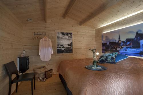 a bedroom with a bed and a table and a tv at Lodgehotel de Lelie in Makkum