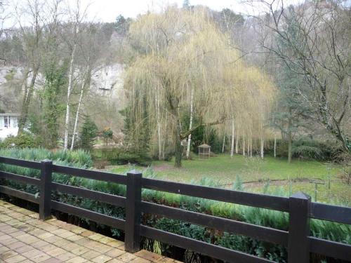 una cerca frente a un parque con un árbol en Home with garden beside the Ourthe and the RAVeL en Comblain-au-Pont