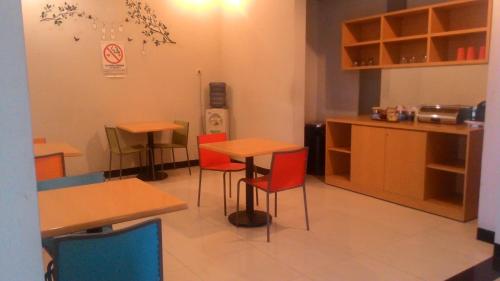 a restaurant with tables and chairs in a room at SWK 95 Hotel in Surabaya