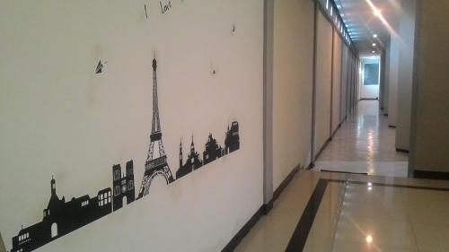 a hallway with drawings of monuments on the wall at SWK 95 Hotel in Surabaya