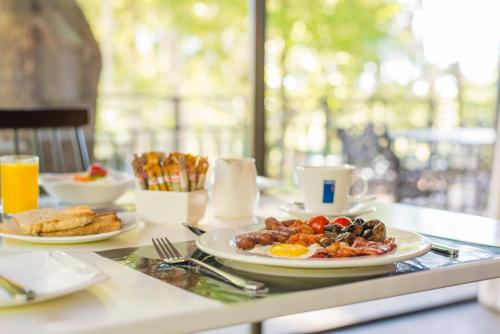 a table with a plate of breakfast food on it at Dunkeld Country & Equestrian Estate in Dullstroom