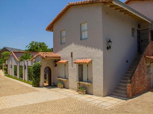 a large white house with a brick driveway at Maison H Guest House in Durban