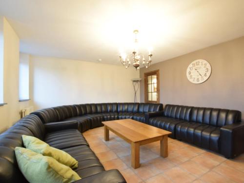 sala de estar con sofá de cuero y mesa en Holiday Home in Gouvy Ardennes with Sauna, en Rogery