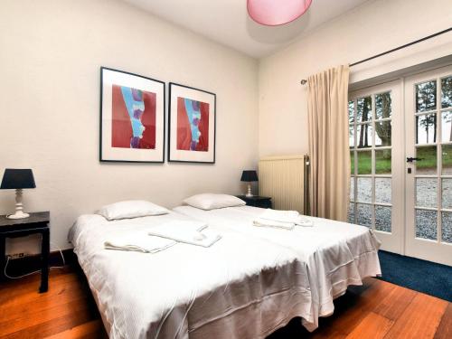 - une chambre avec un grand lit blanc et 2 fenêtres dans l'établissement Luxurious Holiday Home in erezee with Jacuzzi, à Érezée