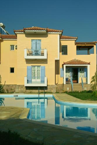 a building with a swimming pool in front of a house at Villa Marita in Lisvórion