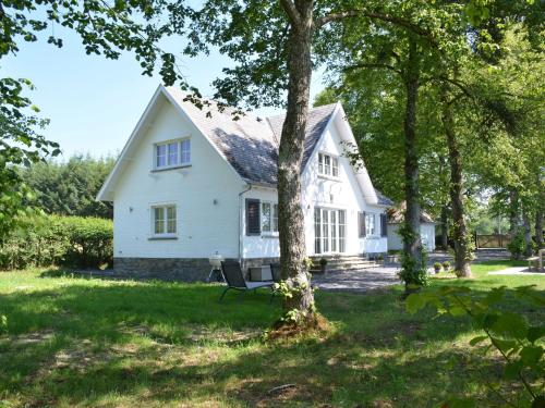 una casa blanca con árboles delante de ella en Superb holiday home with garden in Serinchamps, en Serinchamps