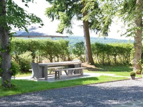 una mesa de picnic y una sombrilla en un parque en Superb holiday home with garden in Serinchamps, en Serinchamps