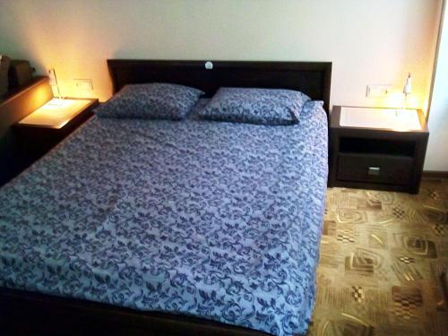 リヴィウにあるSkovoroda apartmentのベッドルーム1室(青いベッド1台、ナイトスタンド2台付)