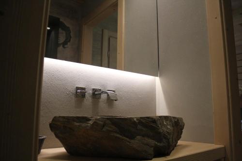 a bathroom with a rock sink in front of a mirror at Albergo Chalet Lago Antorno in Misurina