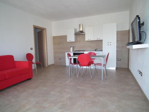 a living room with a red couch and a table and chairs at fausthome in Assemini