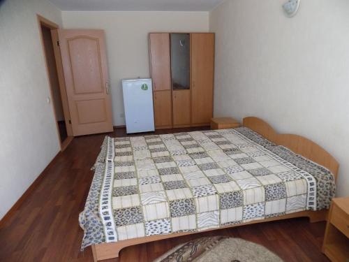 Schlafzimmer mit einem Bett und einem Kühlschrank in der Unterkunft Elektromash Hotel in Tiraspol