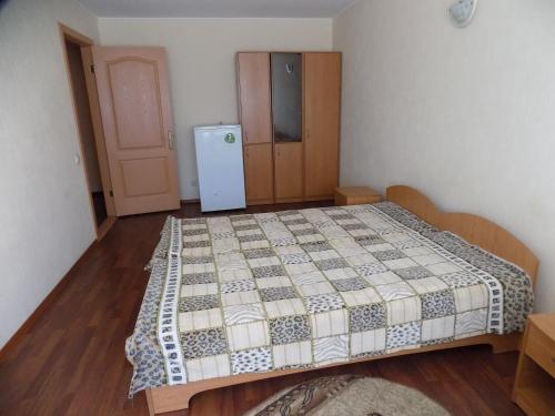 a bedroom with a bed and a refrigerator at Elektromash Hotel in Tiraspol
