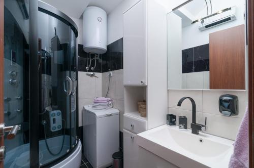 ein Bad mit einer Dusche, einem Waschbecken und einem WC in der Unterkunft Split Center Apartment in Split