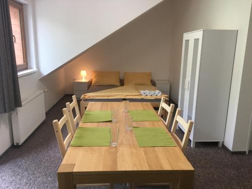 a room with a wooden table with chairs and a bed at Apartments Otre Frymburk in Frymburk