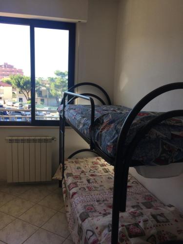 a bedroom with two bunk beds and a window at Roseto degli Abruzzi Fronte Mare in Roseto degli Abruzzi