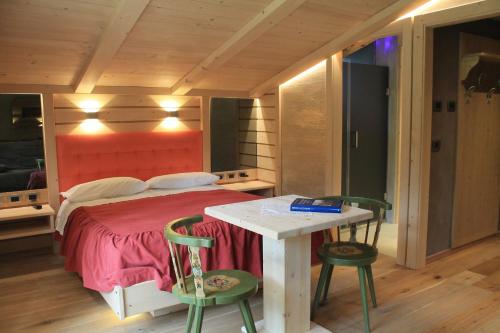 a bedroom with a bed and a table and chairs at Albergo Chalet Lago Antorno in Misurina