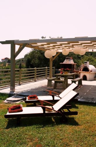 a table and chairs on the grass under an umbrella at Niriides in Porto Koufo