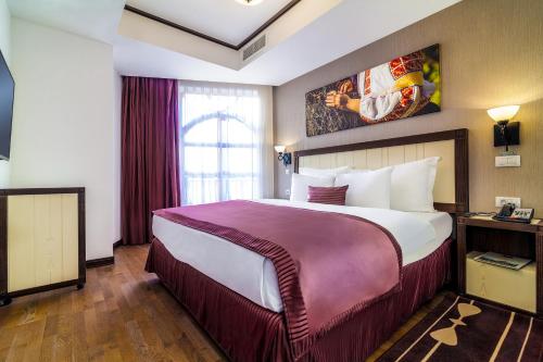 a hotel room with a large bed and a window at Epoque Hotel - Relais & Chateaux in Bucharest