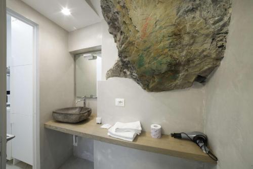baño con lavabo y una roca en la pared en La Casa del Gallerista, en Manarola