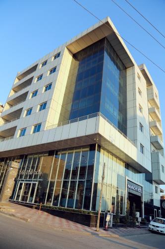 a large building with glass windows on a street at Hotel Halwachy in As Sulaymānīyah