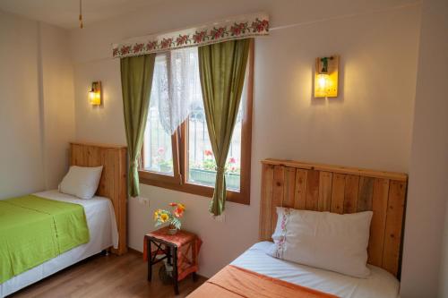 a bedroom with two beds and a window at Dalgaci Deniz Konukevi in Ayvalık