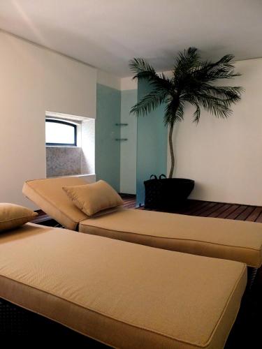 a room with three beds with a palm tree on the wall at Family Secrets Santo André in Santa Maria Da Feira