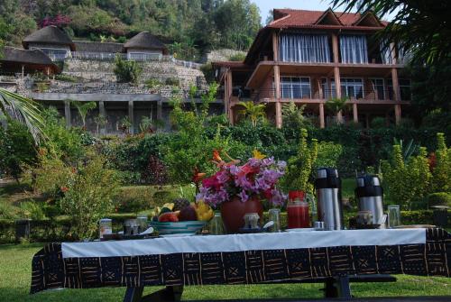 a table with food and flowers in front of a house at Hakuna Matata Lodge in Gisenyi
