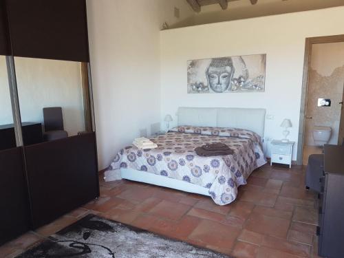 a bedroom with a bed and a picture on the wall at Stazzo Serafini in Rena Majore