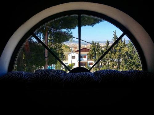 a round window with a view of a house through it at Cabana del Tio Pepe in Ainzón
