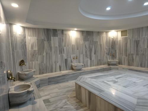 a bathroom with two toilets and a large tub at Zarha Mountain Resort in Sürmene