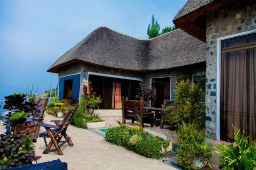 a house with a thatched roof and a patio at Hakuna Matata Lodge in Gisenyi