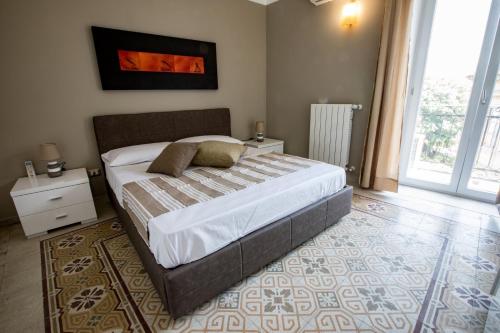 1 dormitorio con cama grande y ventana grande en Vittorio Emanuele Appartamenti, en Palermo