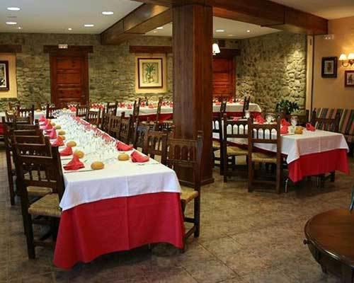 una fila de mesas en un restaurante con manteles rojos y blancos en Tres Picos, en Eriste