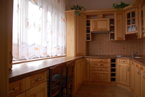 a kitchen with wooden cabinets and a sink and a window at Apartman Horni Adrspach in Adršpach