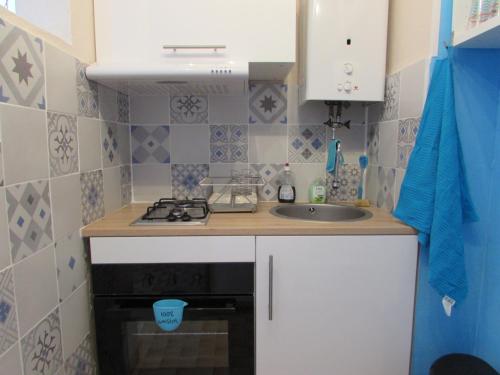 a small kitchen with a sink and a stove at Studio 4 pers, au calme, parking privé, wifi, linges fournis, 2 étoiles de France in La Grande Motte